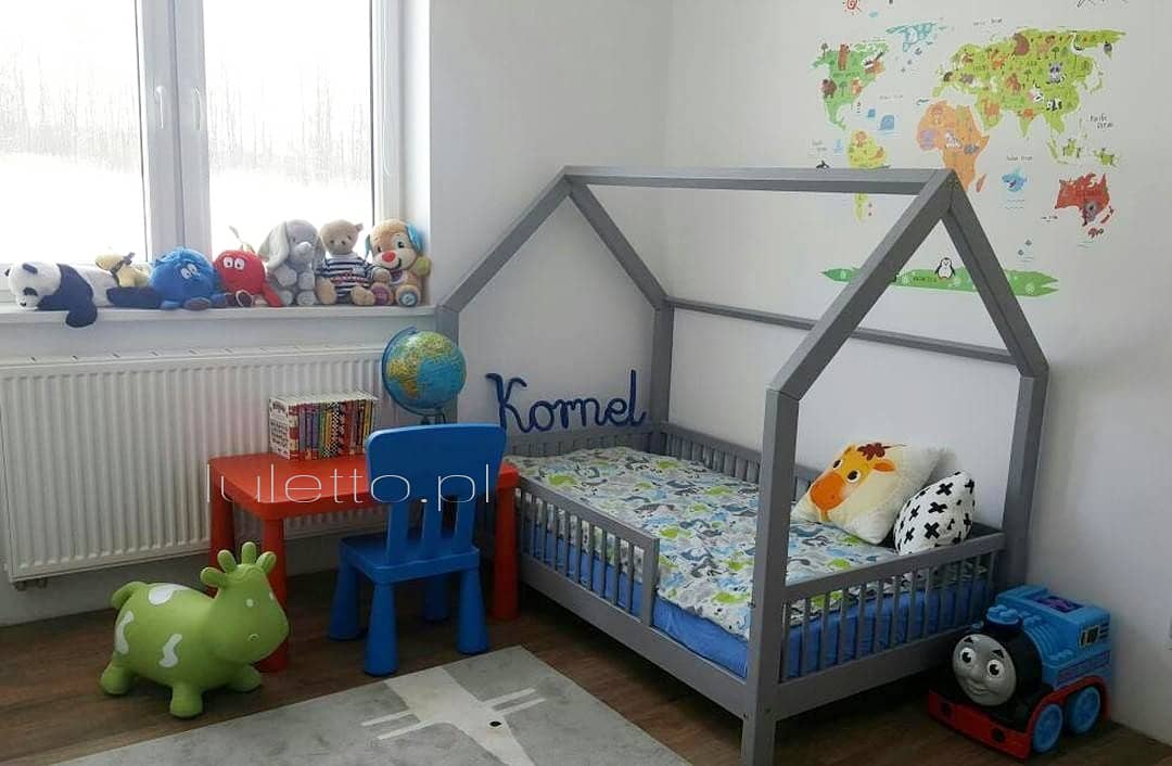 Lit gris dans une chambre de bébé garçon avec des jouets colorés.