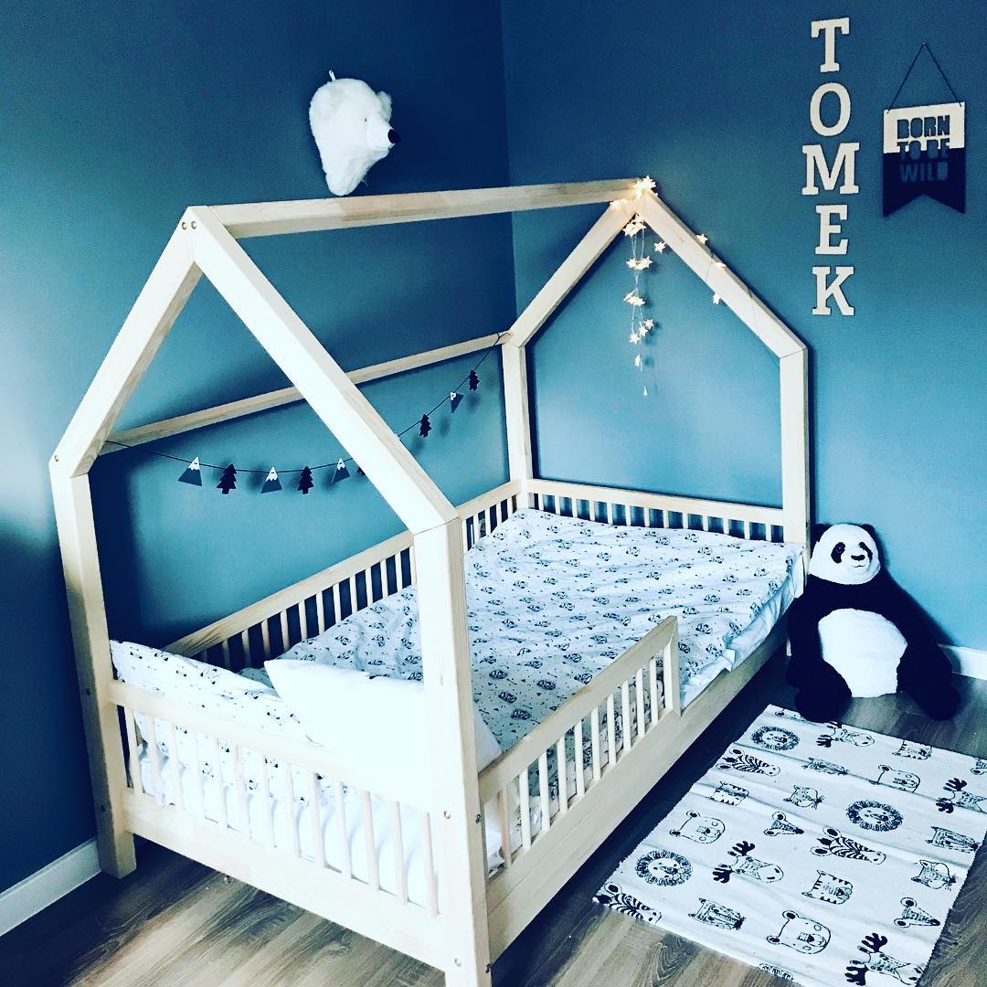 Lit maison en bois pour une chambre de bébé garçon avec décoration d’animaux.