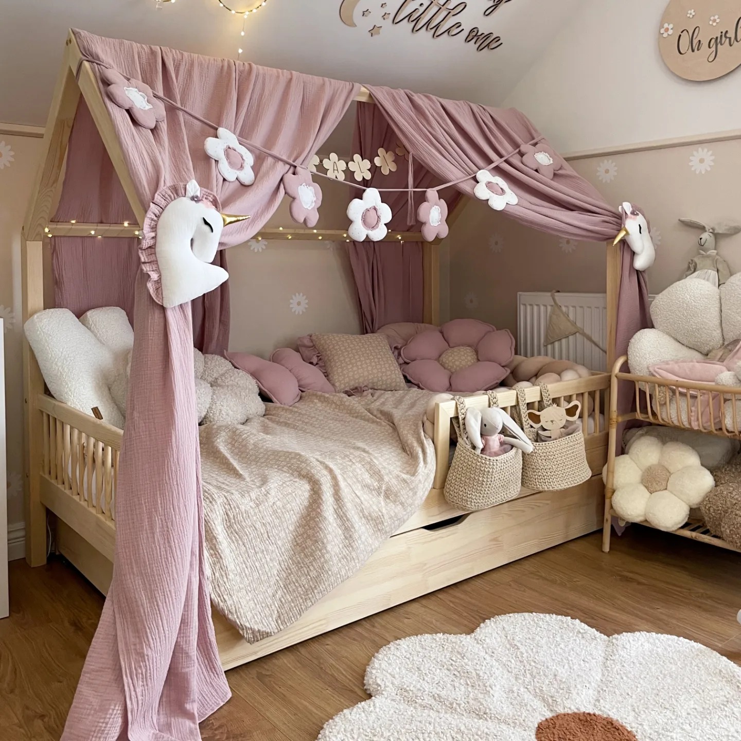 Chambre bébé fille avec lit en bois et décoration douce en rose et blanc